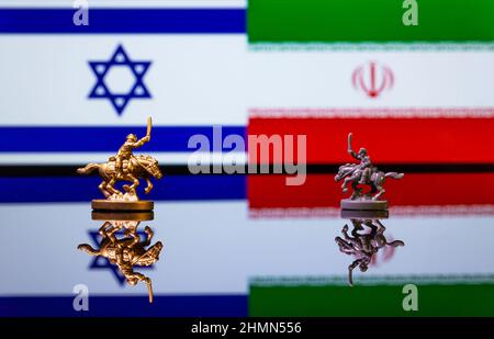 Image conceptuelle de la guerre entre Israël et l'Iran en utilisant des soldats jouets et des drapeaux nationaux sur un fond réfléchissant Banque D'Images