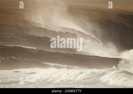 Vagues ensoleillées s'écrasant sur la côte rocheuse, Orcades Banque D'Images