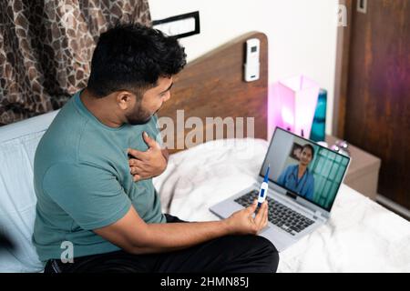 Un malade indien qui parle par appel vidéo d'un médecin consultant sur ordinateur portable à la chambre - concept de soins de santé, consultation en ligne et télémédecine Banque D'Images