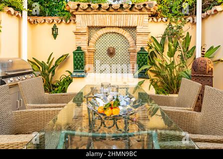 une image d'une table à manger extérieure avec une fontaine en arrière-plan Banque D'Images