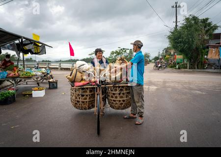 Province de Binh Dinh, Vietnam - 3 janvier 2022 : un agriculteur vend des poêles faits à la main qui sont transportés sur une vieille bicyclette dans la province de Binh Dinh, Vietnam Banque D'Images