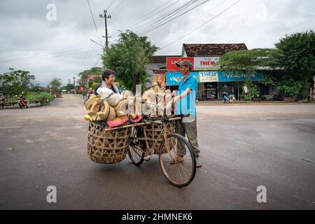 Province de Binh Dinh, Vietnam - 3 janvier 2022 : un agriculteur vend des poêles faits à la main qui sont transportés sur une vieille bicyclette dans la province de Binh Dinh, Vietnam Banque D'Images