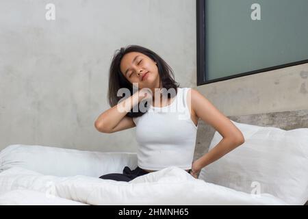 Jeune asiatique belle femme s'étirant heureux et détendu après le réveil se sentir frais à la maison Banque D'Images