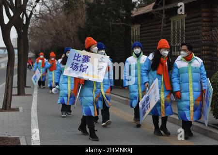 Pékin, Chine. 11th févr. 2022. Les volontaires portant des masques pour les Jeux Olympiques d'hiver de 24th marchent près du Nid d'oiseau à Beijing après avoir terminé leurs travaux.Un programme de nouvelles de CCTV s'est concentré sur les volontaires des Jeux Olympiques d'hiver de Beijing. Selon son rapport, plus de 18 000 bénévoles ont servi dans différents endroits à l'intérieur et à l'extérieur des Jeux, diffusant l'amitié et la chaleur de différentes façons. (Photo de Sheldon Cooper/SOPA Images/Sipa USA) crédit: SIPA USA/Alay Live News Banque D'Images