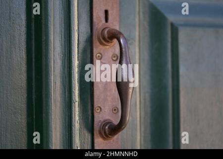 Ancienne maison néoclassique porte d'entrée en bois vert cyprès avec une ancienne poignée en laiton vintage à Nafplio, Grèce. Banque D'Images