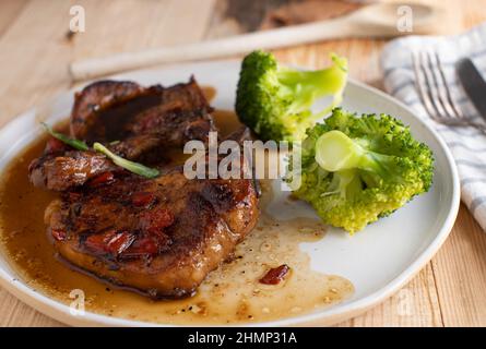 Côtelettes de porc à la délicieuse cassonade, sauce à l'ail. Servi avec du brocoli sur une assiette. Prêt à manger Banque D'Images