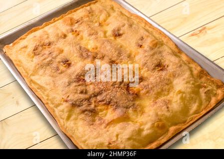 Focaccia de Recco, Ligurie, Italie. Pain focaccia au fromage doux fait avec de la farine et de l'huile d'olive dans une casserole sur des planches de bois Banque D'Images