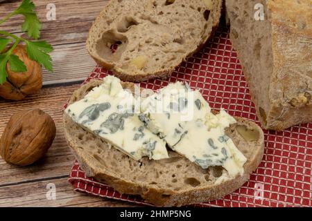 tranche de pain aux noix au fromage roquefort sur fond de bois Banque D'Images