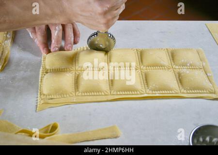 chef utilisant le disque de coupe sur raviolis faits maison Banque D'Images