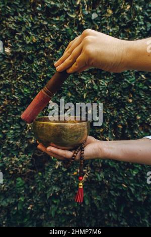 femme non reconnue jouant au bol de chant tibétain Banque D'Images