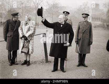 Winston Churchill lève son chapeau en hommage lors d'une inspection de l'escadron américain 1st de la garde à domicile à Horse Guards Parade, à Londres, en 1941 Banque D'Images