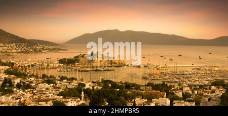 Vue de dessus de la mer avec yacht dans le port de Bodrum. Paysage de la ville avec le château de Saint-Pierre au coucher du soleil. Banque D'Images