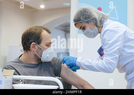 Moscou, Russie. 11th févr. 2022. Un homme est vacciné contre le COVID-19 dans le centre de vaccination du MAGASIN GUM à Moscou, en Russie, le 11 février 2022. La Russie a enregistré 203 949 nouveaux cas de COVID-19 au cours des 24 dernières heures, soit la plus forte augmentation d'un jour à ce jour, portant le nombre national à 13 731 794, a déclaré vendredi le centre officiel de suivi et de réponse. Credit: Evgeny Sinitsyn/Xinhua/Alay Live News Banque D'Images