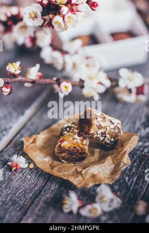 Collection printanière de bonbons au chocolat faits main bonbons et fleurs de cerisier décoration sur fond rustique en bois Banque D'Images