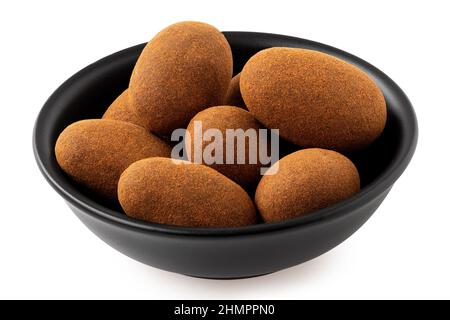 Amandes enrobées de cannelle et de chocolat dans un bol en céramique noire isolé sur blanc. Banque D'Images