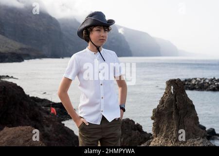 Portrait d'un adolescent sur la toile de fond des falaises de Los Gigantes. Ténérife. Îles Canaries. Espagne. Banque D'Images