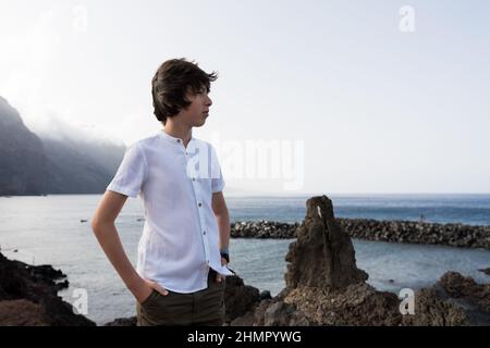 Portrait d'un adolescent sur la toile de fond des falaises de Los Gigantes. Ténérife. Îles Canaries. Espagne. Banque D'Images