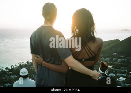 Couple interracial regardant le lever du soleil à Lanikai, Oahu, Hawaii Banque D'Images