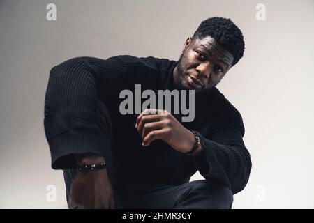 Hommes noirs américains avec une expression sérieuse assis fond blanc - prise de vue moyenne. Photo de haute qualité Banque D'Images