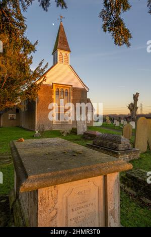 La lune au-dessus de l'église Saint-Margare Ifield près de Gravesend au coucher du soleil en hiver Banque D'Images