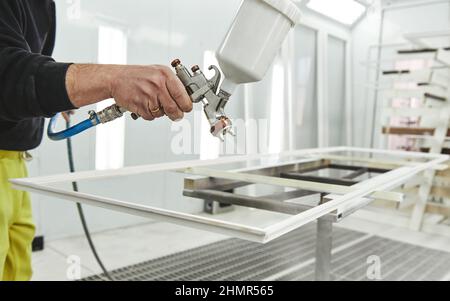 Peinture professionnelle de qualité. L'homme tient un vaporisateur aérographe pour la peinture et la teinture Banque D'Images