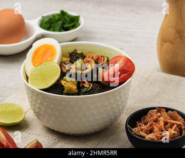 Soto Babatt, soupe indonésienne traditionnelle à base de bouillon et de tripe, servi dans Un bol avec œufs et tomates Banque D'Images