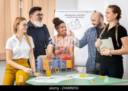 Équipe d'architectes mixtes multiethniques travaillant sur les plans de construction dans la salle de réunion Banque D'Images