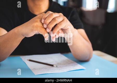 L'homme travaille à la maison. Puis ses doigts douleur. Concept de syndrome de bureau. Gros plan moyen. Banque D'Images