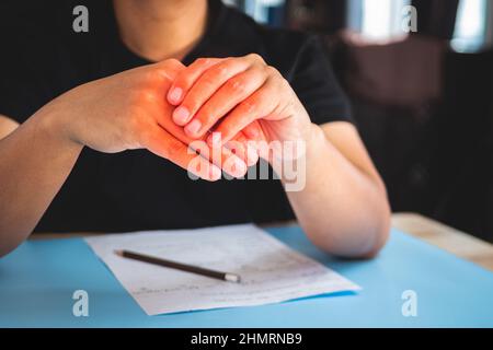 L'homme travaille à la maison. Puis ses doigts douleur. Concept de syndrome de bureau. La zone des symptômes de douleur est indiquée en rouge. Gros plan moyen. Banque D'Images