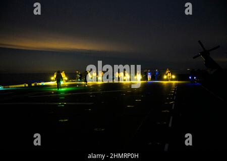 USPACOM, en mer. 10th janvier 2022. Des marins effectuent une promenade de débris d'objets étrangers sur le pont de vol du navire d'assaut amphibie USS Tripoli (LHA 7), janvier 11. Tripoli mène actuellement des opérations de routine dans la flotte américaine 3rd. Credit: U.S. Navy/ZUMA Press Wire Service/ZUMAPRESS.com/Alamy Live News Banque D'Images