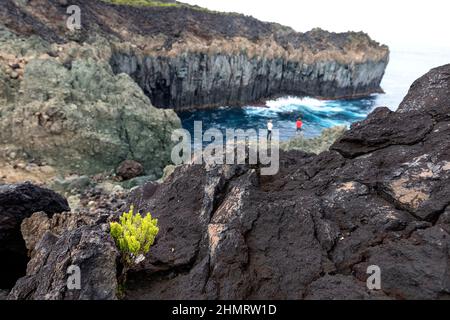 Mère et fils debout sur des formations rocheuses étonnantes à Baias da Agualva, île de Terceira, Açores, Portugal Banque D'Images