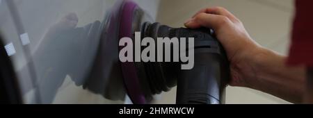 Le maître polit la carrosserie de la voiture des éraflures et des rayures de près Banque D'Images