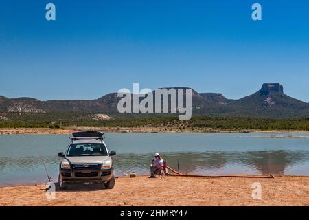 Femme pêcheur à la ligne au lac Tsaile, Tsaile Butte sur la droite dans Dist, Chuska Mountains, Canyon de Chelly Natl Monument, près de Tsaile, Navajo Nation, Arizona, États-Unis Banque D'Images