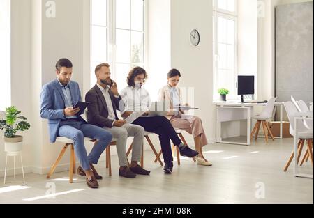 Groupe de personnes assis au bureau et en attente d'une entrevue d'emploi ou d'une réunion d'affaires Banque D'Images