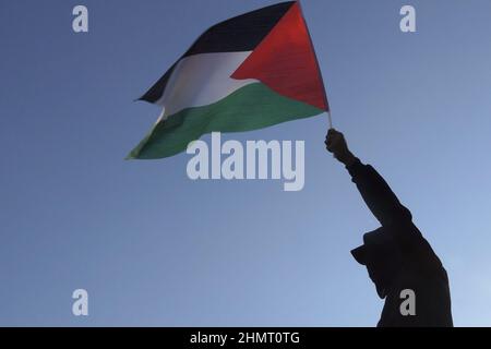 Un homme palestinien détient le drapeau palestinien lors d'une manifestation contre l'occupation israélienne et les activités de colonisation dans le quartier de Sheikh Jarrah le 11 février 2022 à Jérusalem, en Israël. Le quartier palestinien de Sheikh Jarrah est actuellement au centre d'un certain nombre de conflits de propriété entre Palestiniens et Israéliens juifs de droite. Certaines maisons ont été occupées par des colons israéliens à la suite d'une décision du tribunal. Banque D'Images