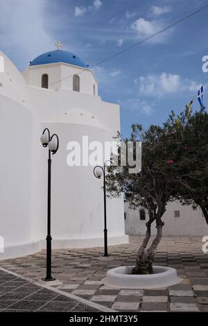 Vue sur une église orthodoxe blanchie à la chaux avec drapeaux byzantins et grecs à Santorini Grèce Banque D'Images