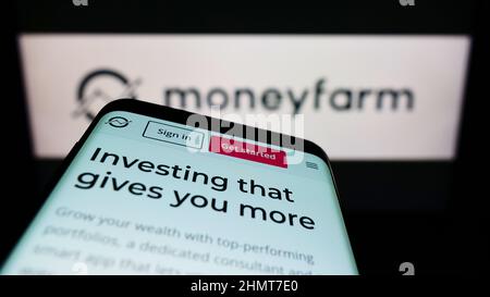 Téléphone mobile avec le site Web de la société britannique de conseil en investissement Moneyfarm à l'écran devant le logo. Faites la mise au point dans le coin supérieur gauche de l'écran du téléphone. Banque D'Images