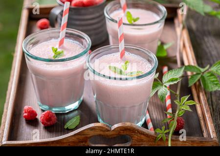 Cocktail maison avec fruits de saison et lait. Smoothie frais à la framboise pour le petit-déjeuner. Banque D'Images