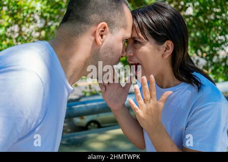 Un jeune couple latin ou un couple marié ayant un combat chauffé dans la rue. Concept de combat, coupure de coeur, couple, discussion. Banque D'Images