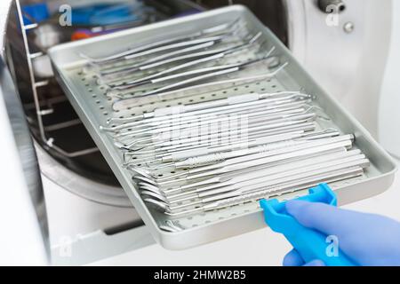 Une femme dentiste place un autoclave médical pour stériliser les instruments chirurgicaux et autres Banque D'Images