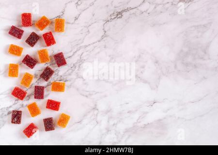 Différents goûts de pâte de fruits sur fond de marbre, vue de dessus, espace de copie Banque D'Images