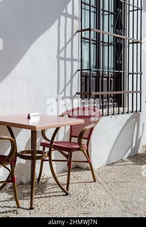 Table réservée sur un bar à Osuna, Séville, Espagne. Mur blanchi à la chaux et fenêtre en treillis d'acier. Banque D'Images