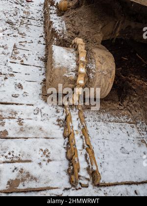 Détails rouillés de l'ancien tracteur à chenilles abandonné. Les pignons, les chaînes et les poulies rouillent dans l'ouverture Banque D'Images