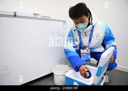 (220212) -- BEIJING, le 12 février 2022 (Xinhua) -- Un membre du personnel dépose un disque de hockey sur glace dans une boîte de refroidissement au Wukesong Sports Centre de Beijing, capitale de la Chine, le 10 février 2022. Comme les joueurs chinois de hockey sur glace se sont présentés aux Jeux olympiques d'hiver de 2022 à Beijing, ce jeu attire de plus en plus l'attention du public. Au centre sportif Wukesong de Beijing, le personnel travaillant pour les épreuves de hockey sur glace a placé les rondelles de glace dans des glacières. Le disque, en caoutchouc vulcanisé, est un disque dur plat qui doit être gelé avant le jeu pour réduire l'élasticité pendant le jeu. Les hommes et les femmes Banque D'Images