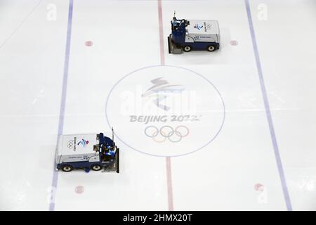 (220212) -- BEIJING, le 12 février 2022 (Xinhua) -- des membres du personnel utilisent des camions de réparation de glace pour faire la surface de la patinoire à plat pendant la pause du match préliminaire de hockey sur glace des hommes du groupe B entre la République tchèque et le Danemark au stade national intérieur de Beijing, en Chine, le 9 février 2022. Comme les joueurs chinois de hockey sur glace se sont présentés aux Jeux olympiques d'hiver de 2022 à Beijing, ce jeu attire de plus en plus l'attention du public. Au centre sportif Wukesong de Beijing, le personnel travaillant pour les épreuves de hockey sur glace a placé les rondelles de glace dans des glacières. La rondelle, en caoutchouc vulcanisé, Banque D'Images