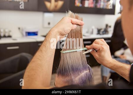 Une jeune femme se coupe dans un salon de beauté Banque D'Images