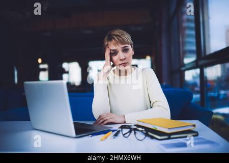 Femme fatiguée avec un ordinateur portable pendant le travail à l'échéance Banque D'Images