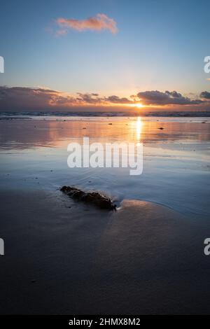 Coucher de soleil avec nuages et réflexions illuminés, à Sandy Gap, plage de Walney, île de Walney, barrow in furness, Cumbria, Royaume-Uni, le 4th février 2022 Banque D'Images