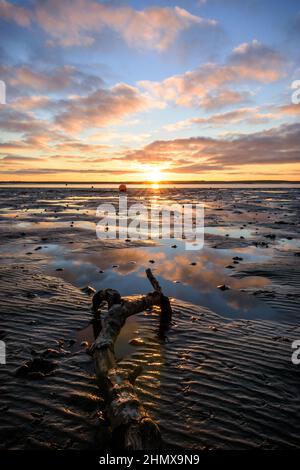 Coucher de soleil lumineux et coloré sur la plage d'hiver capturé au canal de Walney, depuis le rivage de l'île Roa, Rampside, barrow in furness, Lake District, Cumbria, ROYAUME-UNI Banque D'Images
