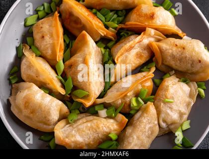 Gyoza croustillant et frits avec oignon de printemps. Cuisine asiatique. Banque D'Images